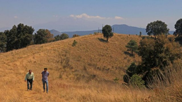 Dos hombres paseando por una colina en Milpa Alta.