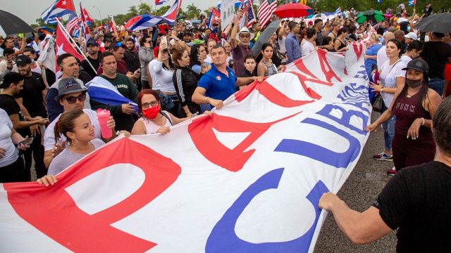 Manifestantes en la autopista Palmetto con banderas de Cuba y una pancarta en la que se lee "Patria y Vida"