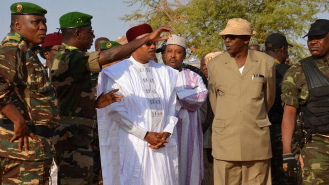 Le président du Niger (en boubou blanc) s'entretient avec des soldats de son pays déployés près de la frontière avec le Mali (photo d'archives).