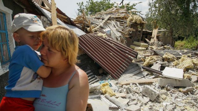 Женщина на развалинах дома