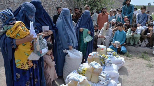 Mulheres afegãs recebem doações de alimentos como parte do Programa Mundial de Alimentos (PMA) para pessoas desalojadas, durante o mês sagrado islâmico do Ramadã em Jalalabad em 20 de abril de 2021