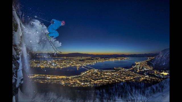 Hombre esquiando de noche