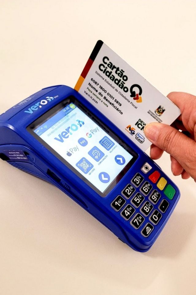 Pessoa passa cartão do programa Devolve ICMS na máquina de pagamento
