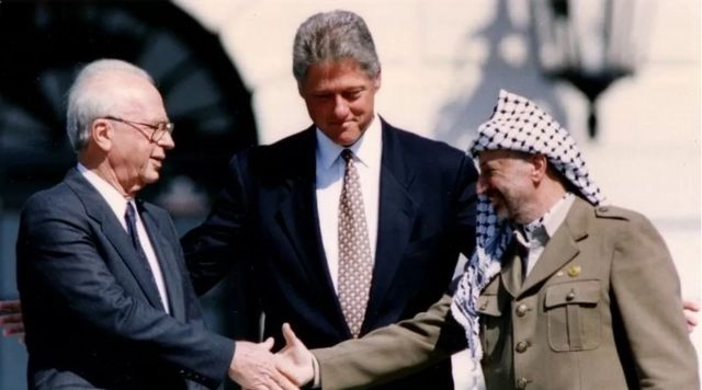 Thủ tướng Israel Yitzhak Rabin và Tổng thống Palestine Yasser Arafat bắt tay Tổng thống Mỹ Bill Clinton vào năm 1993