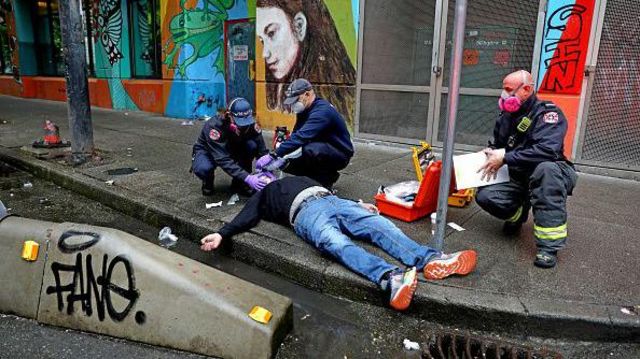 Pessoa em overdose é atendida por médicos nas ruas de Vancouver, Canadá