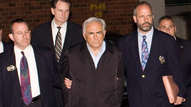 International Monetary Fund chief Dominique Strauss-Kahn, in handcuffs, is walked to a police vehicle outside of a New York City Police Department facility on W. 123rd St. May 15, 2011 in New York City.