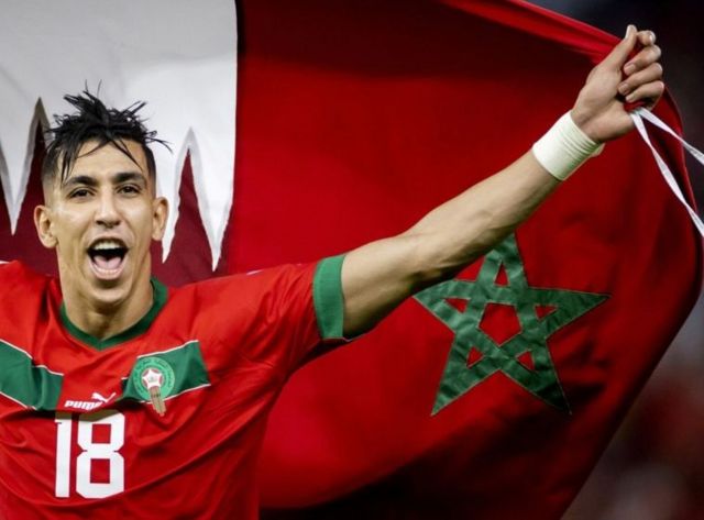 Un joueur marocain brandissant le drapeau national.