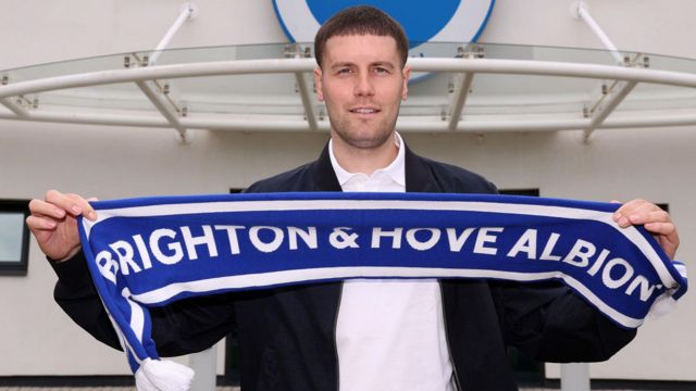 Fabian Hurzeler holds a Brighton scarf