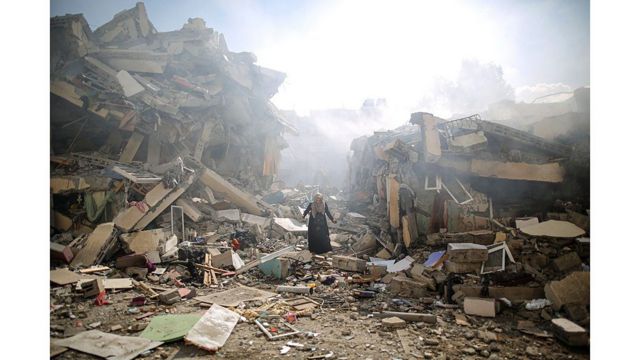 Una mujer se abre paso entre los escombros en la ciudad de Gaza 