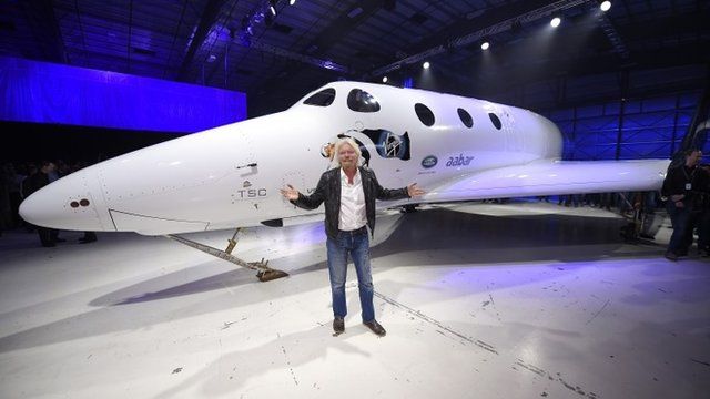 Sir Richard Branson poses in front of his new Virgin Galactic Spaceship