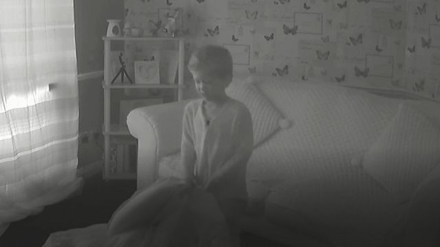 Imagem em preto e branco das câmeras da casa mostram Arthur tentando erguer um cobertor