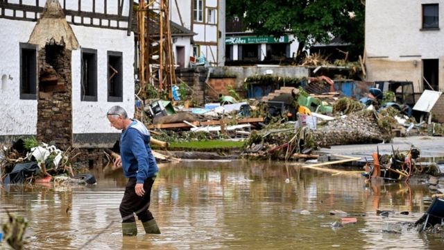 A man crosses a flooded street in Szold, Germany.