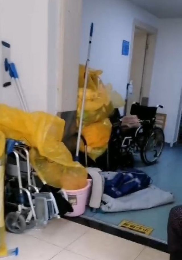 A hospital corridor is filled with piles of rubbish