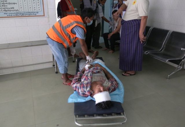 The injured person lies on a stretcher in Mandalay.