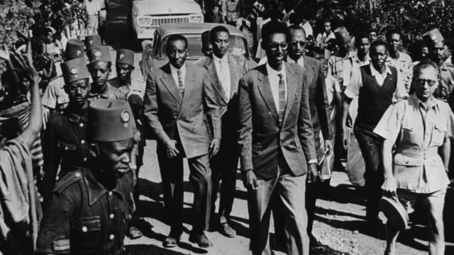 Umwami Kigeli V w'u Rwanda (imbere) akikijwe n'abarinda umutekano n'imbaga y'abaje kumureba igihe yari mu mujyi wa Circa 1959.