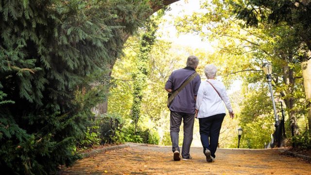 Pareja de personas mayores caminando en un parque