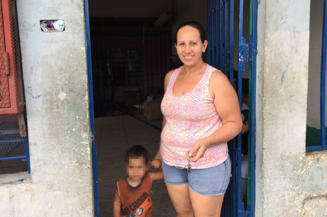 Una costarricense posa con su hijo en la entrada de un "peaje", una casa privada por la que se pasa para llegar a otro barrio y se debe pagar por el acceso.