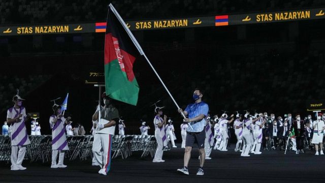 残奥会开幕式上，志愿者举着阿富汗国旗入场。(photo:BBC)