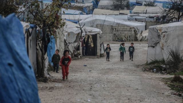 Children walk in the Idlib refugee camp.