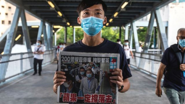 Pro-democracy district councillor Lam Chun holds a copy of the Apple Daily newspaper