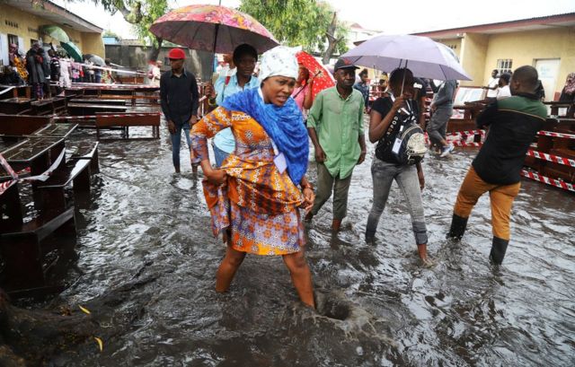 Voters wade through flood water at a polling station during the presidential election in Kinshasa, Democratic Republic of Congo, December 30, 2018