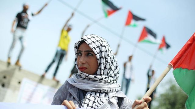 Mulher com bandeira da Palestina