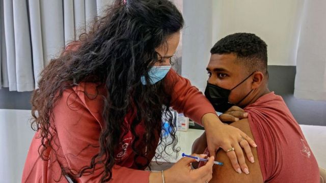 فلسطيني يحصل على تطعيم من عاملة في الصحة الإسرائيلية