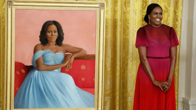 Former US first lady Michelle Obama poses next to her official White House portrait by Sharon Sprung.