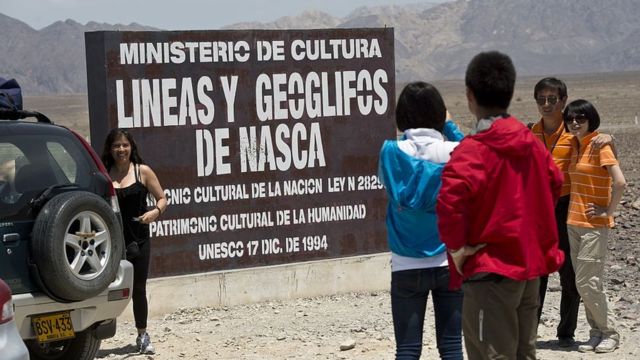 Personas posando ante un cartel de Ministerio de Cultura antes de entrar a ver las líneas de Nasca.