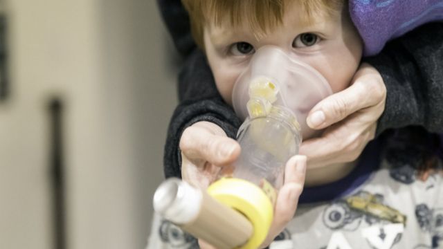 boy with asthma using a spacer device