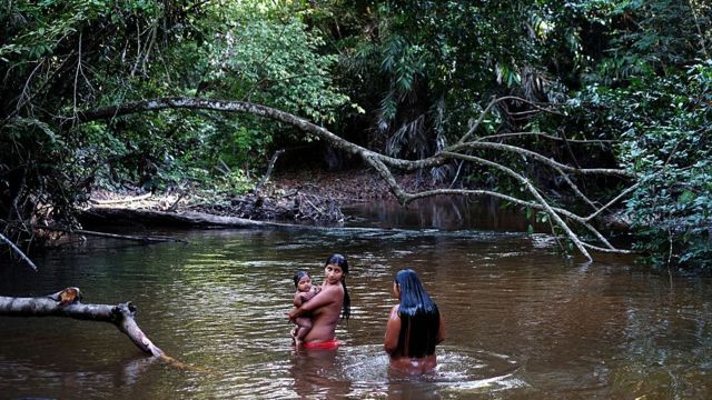 na foto, Syroli Awá toma banho com seu filho Wy no território Awá no Maranhão)
