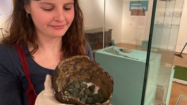 “克里德零-斯塔布斯宝藏”谜团：利兹博物馆和美术馆的考古和钱币学的讲解员展示罐子里面的古罗马铜币(photo:BBC)