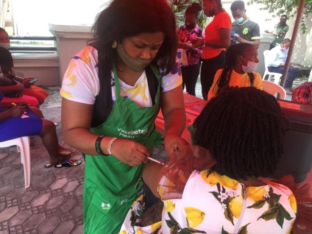 Health worker dey inject woman wit Covid-19 vaccine