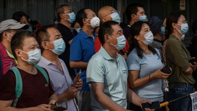 Chinese parents and relatives watch as students, not seen, leave a school after taking the National College Entrance Examination,