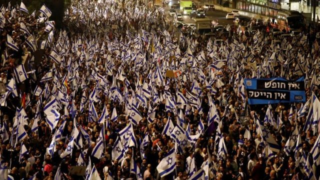 People attend a demonstration after Israeli Prime Minister Benjamin Netanyahu dismissed the defense minister