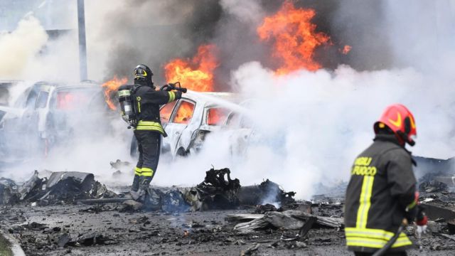 قوات الإطفاء تحاول إخماد النيران في سيارات مشتعلة