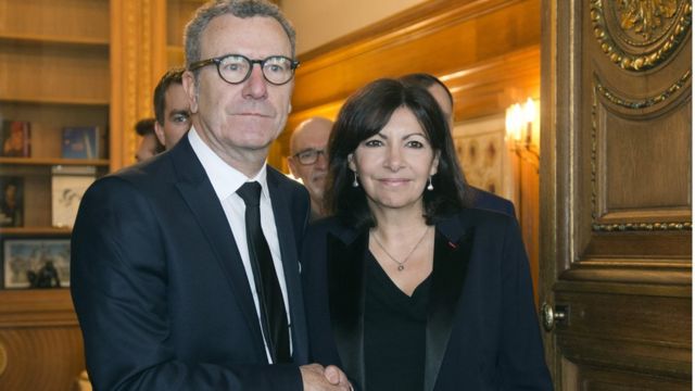 パリ市庁舎で握手するブリュッセルのマイヨール市長とパリのイダルゴ市長（29日）