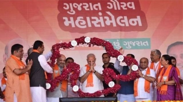 भाजपचे कार्यकर्ते आणि नेते नरेंद्र मोदी आणि अमित शहांना हार घालताना