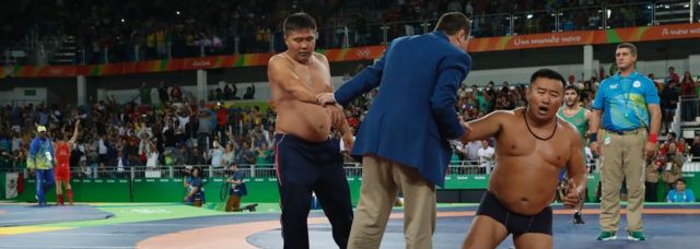 Mongolia's Mandakhnaran Ganzorig's coaches react after the judges announced that Uzbekistan's Ikhtiyor Navruzov won following a video replay in their men's 65kg freestyle bronze medal match on August 21, 2016, during the wrestling event of the Rio 2016 Olympic Games at the Carioca Arena 2 in Rio de Janeiro