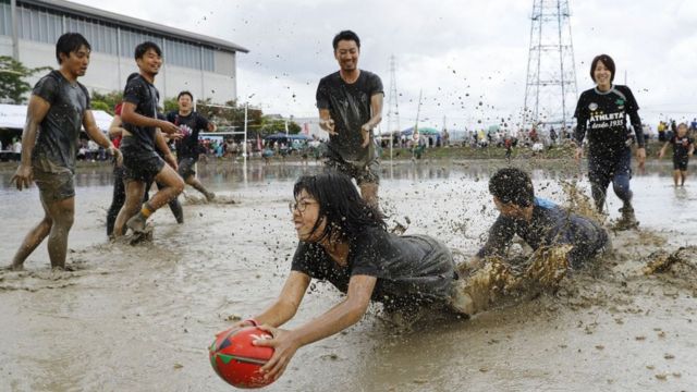Players slosh through a game of tambo rugby in Kyoto, western Japan