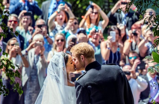 قبلة دوق ودوقة ساسيكس على أعتاب كنيسة سانت جورج في قلعة وندسور في أعقاب زفافهما.