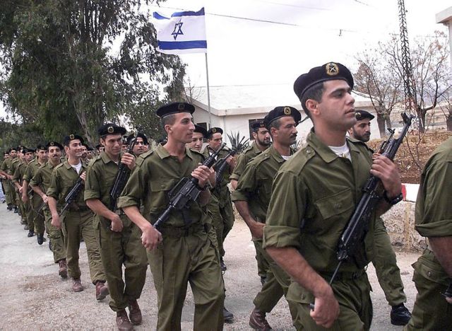 أعضاء ميليشيا جيش لبنان الجنوبي يسيرون إلى جانب علم إسرائيلي خلال حفل تخرج في المجيدية في 25 نوفمبر/تشرين الثاني 1999
