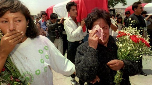Parentes de policiais mortos pelo Sendero Luminoso chorando durante seu funeral nos anos 1990