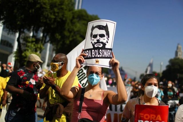 A person holds a sign reading "Bolsonaro out" during a protest calling for the impeachment of Brazil's President Jair Bolsonaro in Rio de Janeiro, Brazil, on 3 July 2021