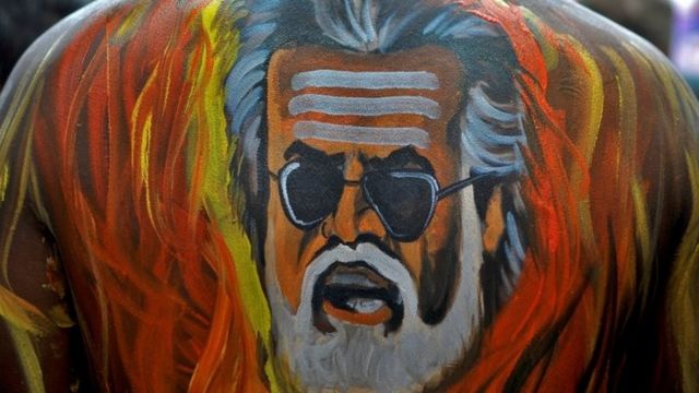 A fan with his body painted with an image of actor Rajinikanth is pictured outside a movie theatre showcasing the Tamil film "Kabali" in Bengaluru