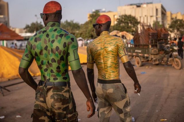 Des hommes portant des peintures corporelles militaires marchent lors d'un rassemblement de soutien aux militaires à Ouagadougou, le 19 février 2022