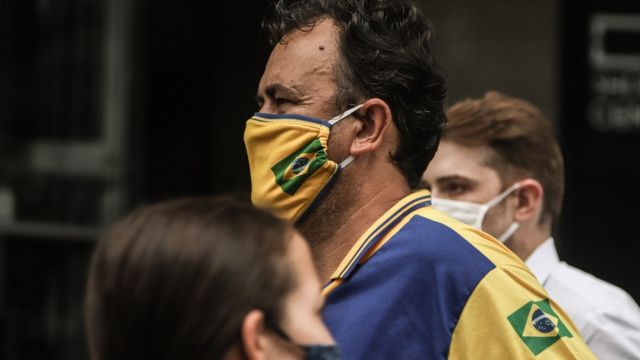 Un hombre en Brasil lleva una mascarilla con la bandera de su país.