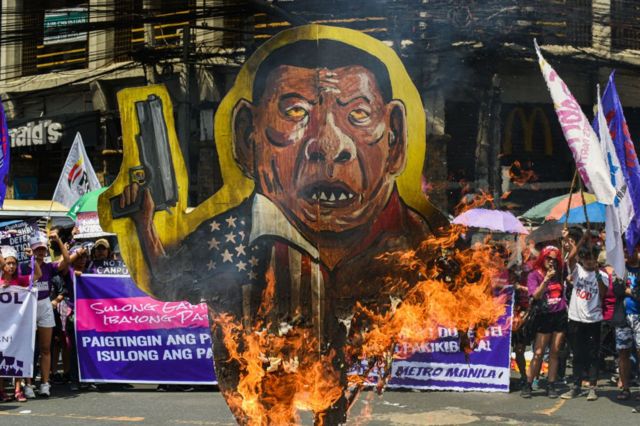 نساء فيلبينيات يحرقن دمية على شكل الرئيس رودريغو دوترتي في مانيلا في مظاهرات اليوم العالمي للمرأة.