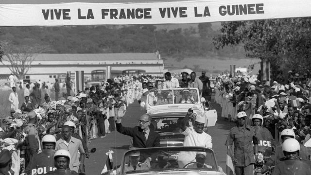 Le président français Valéry Giscard d'Estaing (G) et Ahmed Sékou Touré (D), président de la Guinée, saluent leurs partisans, le 22 décembre 1978, dans les rues de Labe, lors d’une visite officielle de trois jours