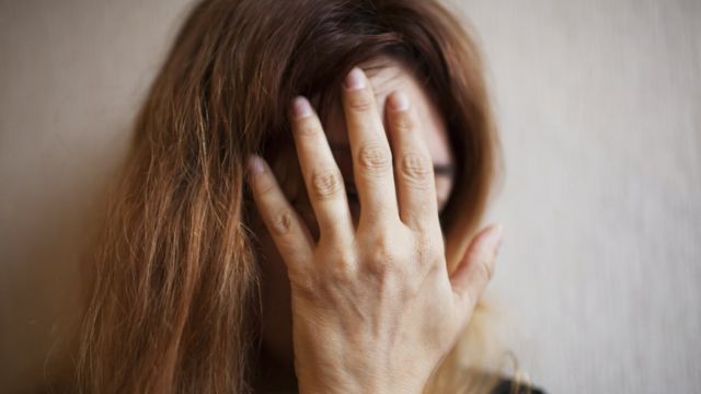 woman covering her face
